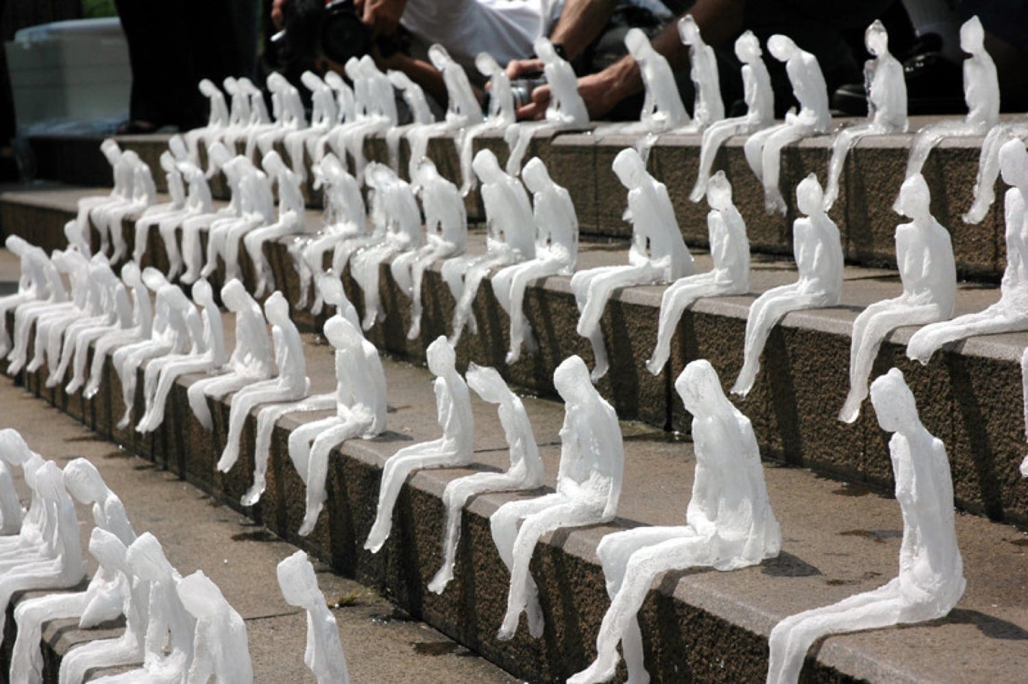 Nele Azevedo's "Melting Men" installation - rows of small ice figures seated on steps, slowly melting.